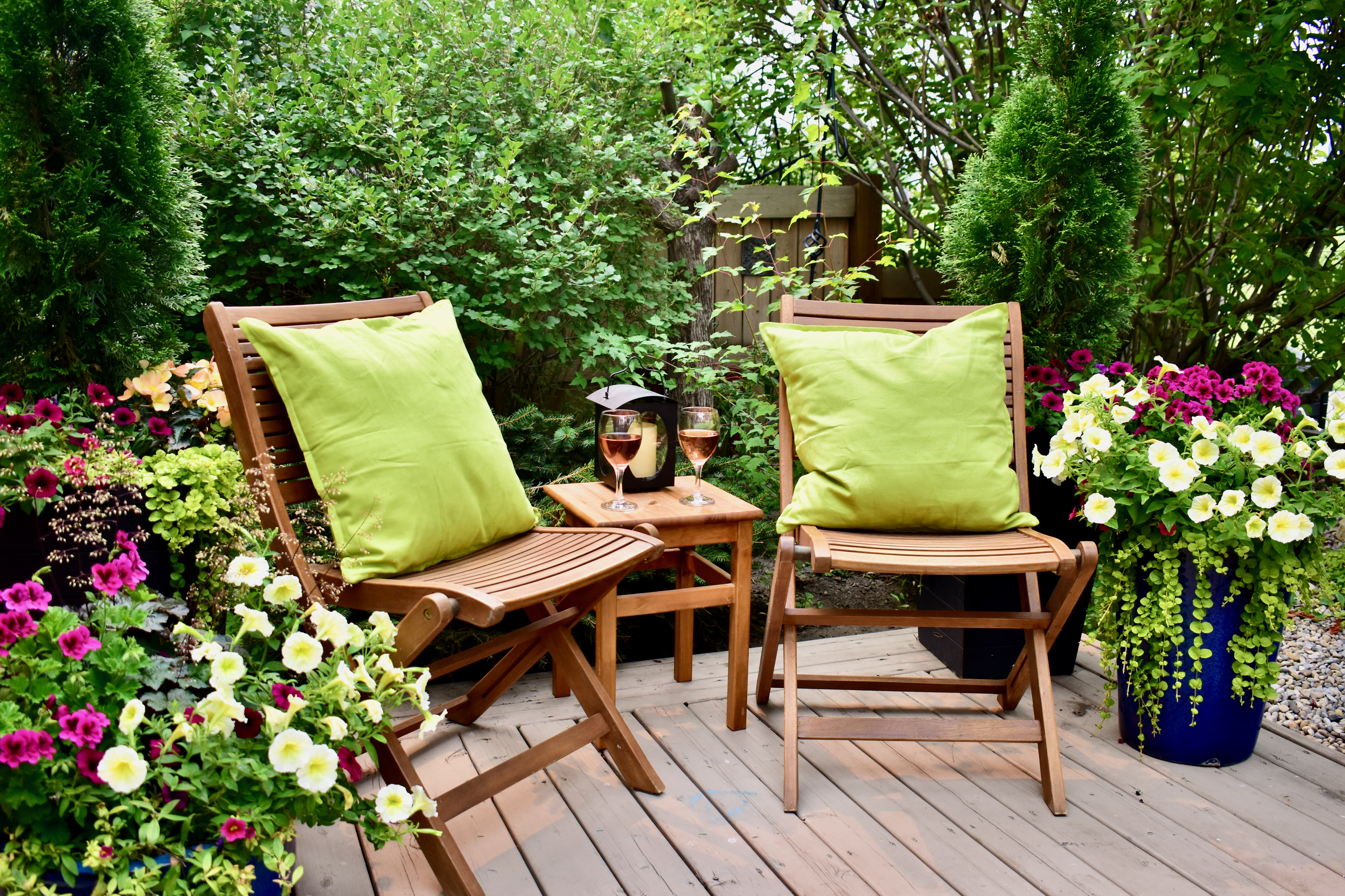 Das grüne Wohnzimmer - gemütliche Plätze im Garten schaffen gemütliche Sitzecke im Garten mit Blumen auf einer holzterrase